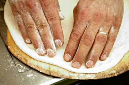 Scott Carrino makes artisan pizza by hand in community bread ovens at the Round House Bakery Cafe. 